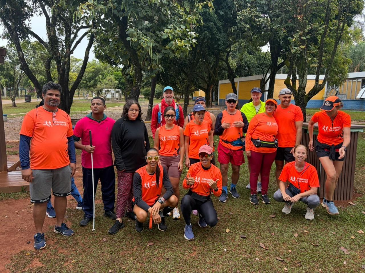 Um corredor segurando uma bengala branca, reunido com o grupo antes de um treino de domingo.
